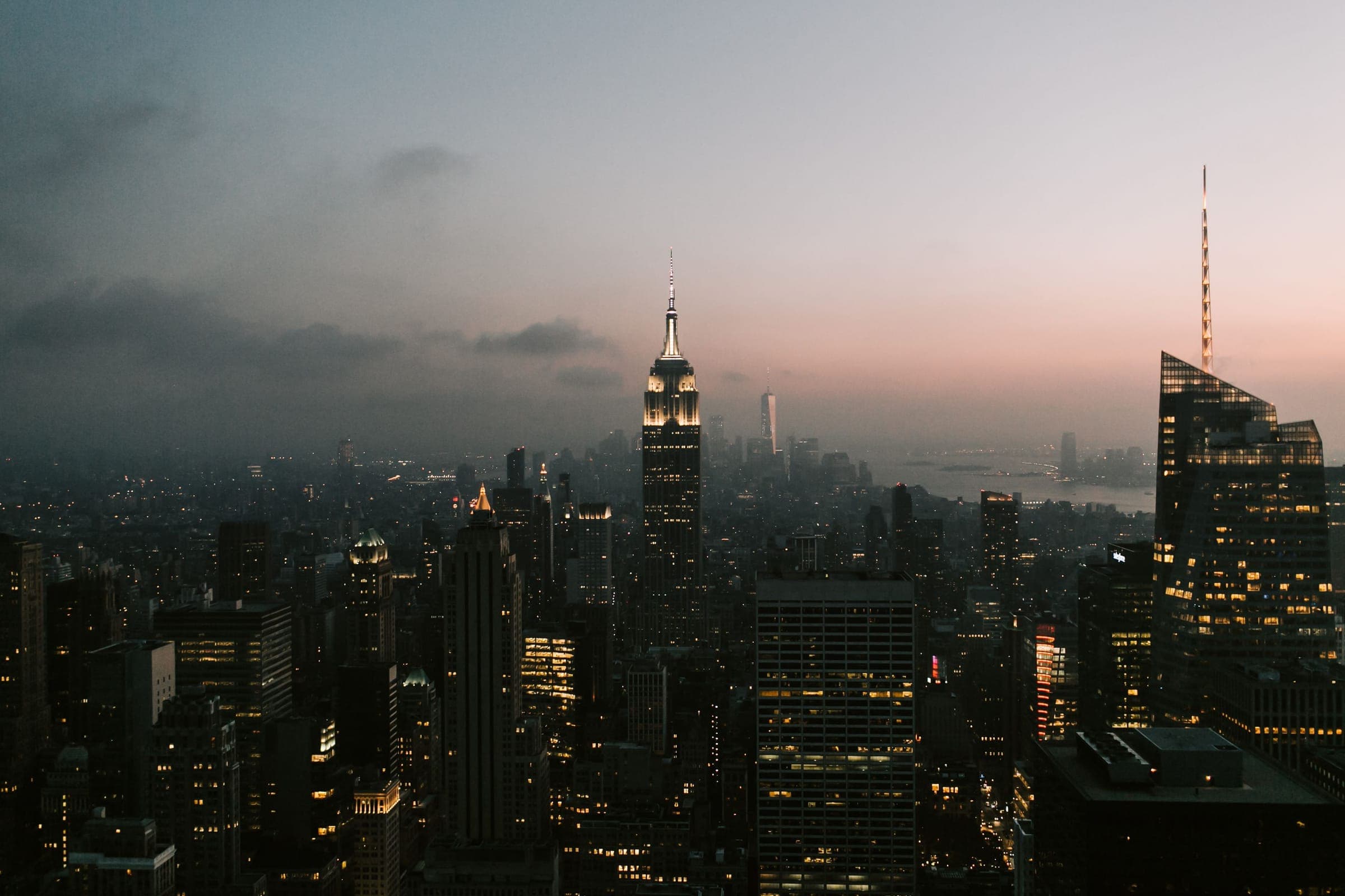 Aerial view of Manhattan at dusk with the Empire State Building rising through haze